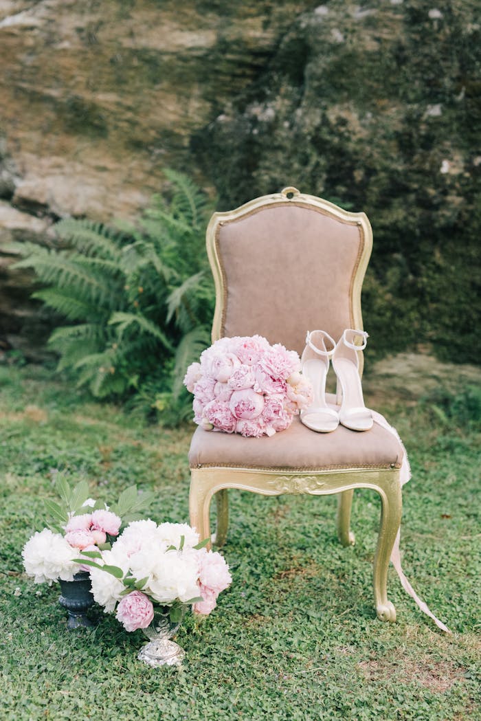 Home Elegant vintage chair with pink bouquet and high heels in an outdoor garden setting.